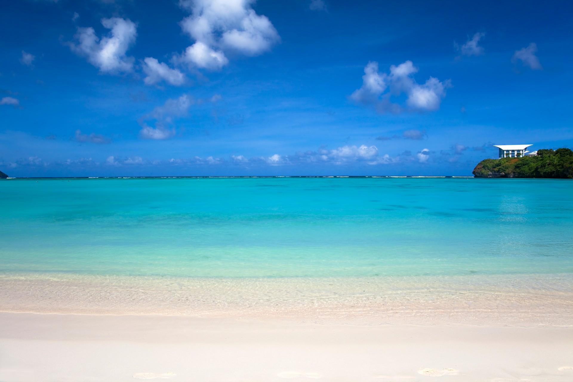 Nice beach by the sea with turquise water near Tumon in sunny weather with few clouds