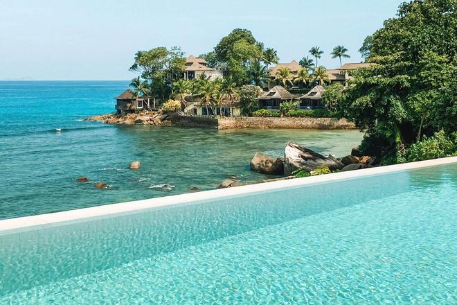 View from a pool overlooking houses, nature, and the sea in Victoria city, Seychelles.