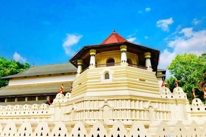 Buddhist temple of Sri Dalada Maligawa with trees in the background