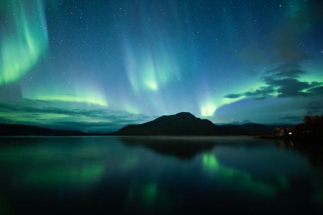 View of a lake, mountain and beautiful Northern Lights in Lapland