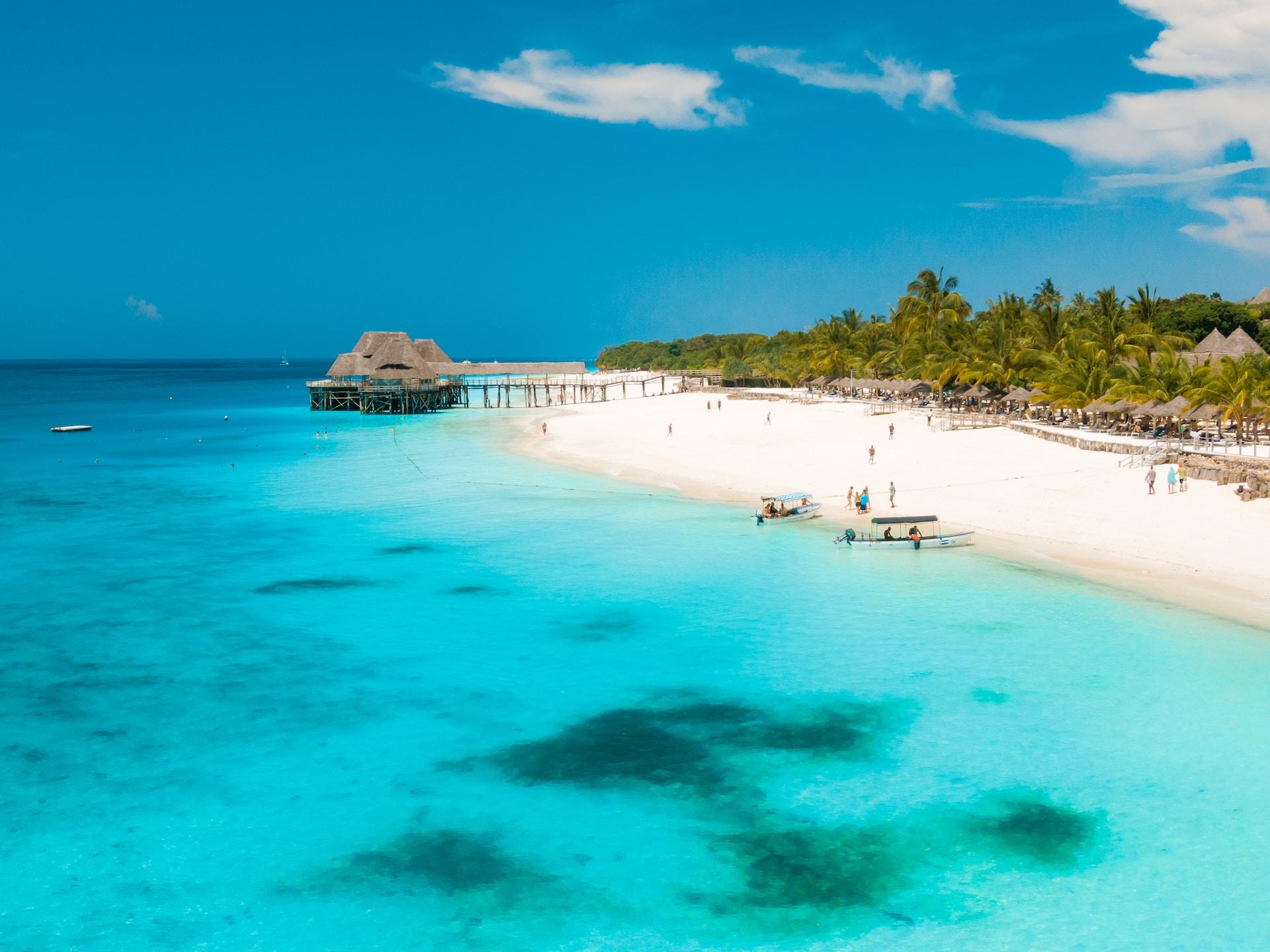 Zanzibar: white beach with palm trees and a gazebo on the sea.