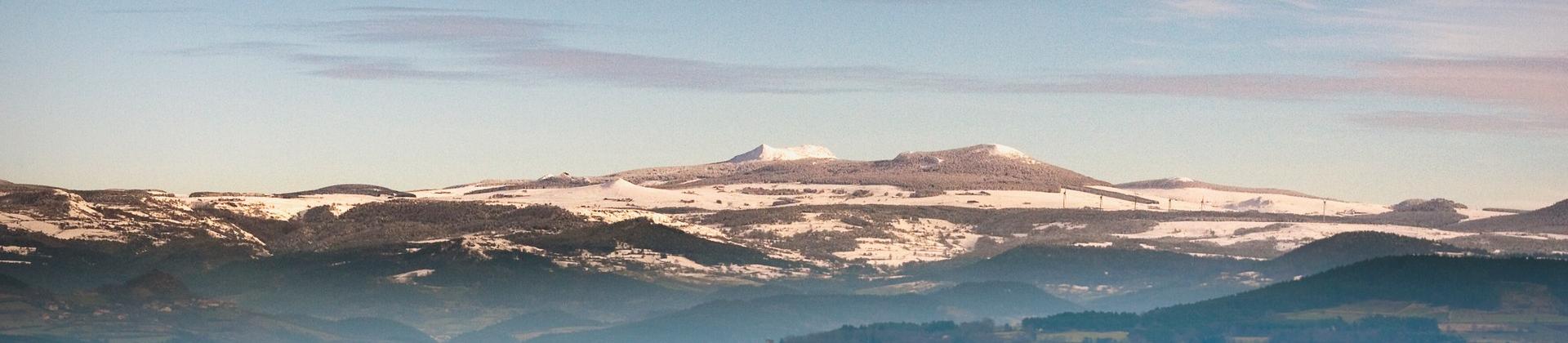 Aerial view of mountain range in Le Puy-en-Velay in sunny weather with few clouds