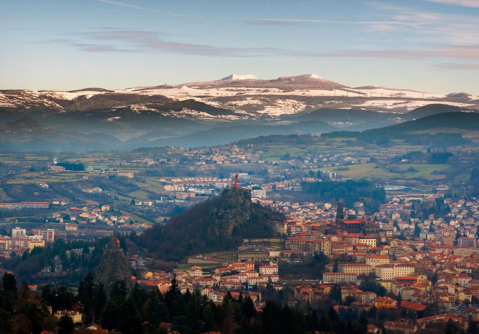 Aerial view of mountain range in Le Puy-en-Velay in sunny weather with few clouds