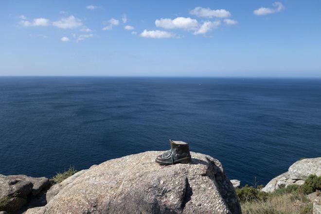 View of a shoe on a rock and an endless ocean in the background, Fisterra