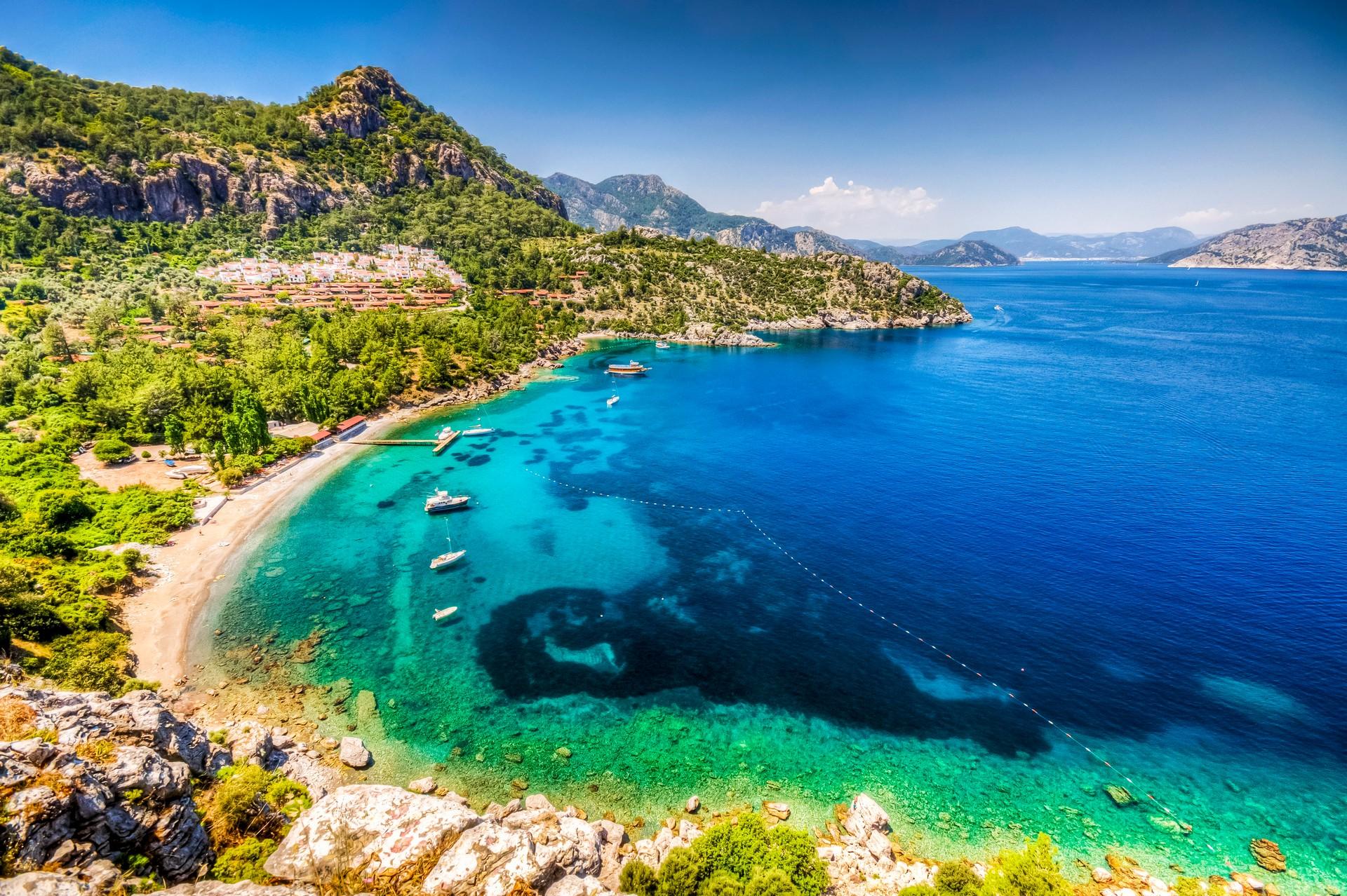 Nice beach by the sea with turquise water in Marmaris in sunny weather with few clouds