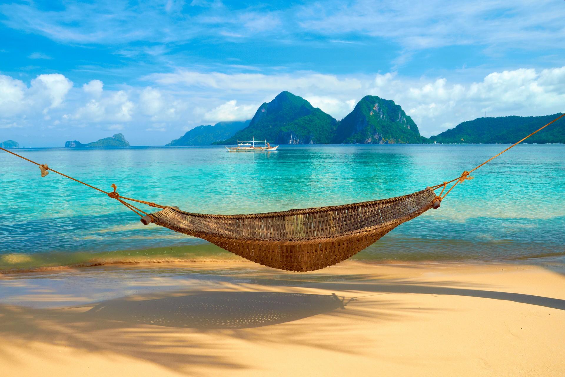 Nice beach by the sea and boat in El Nido on a cloudy day