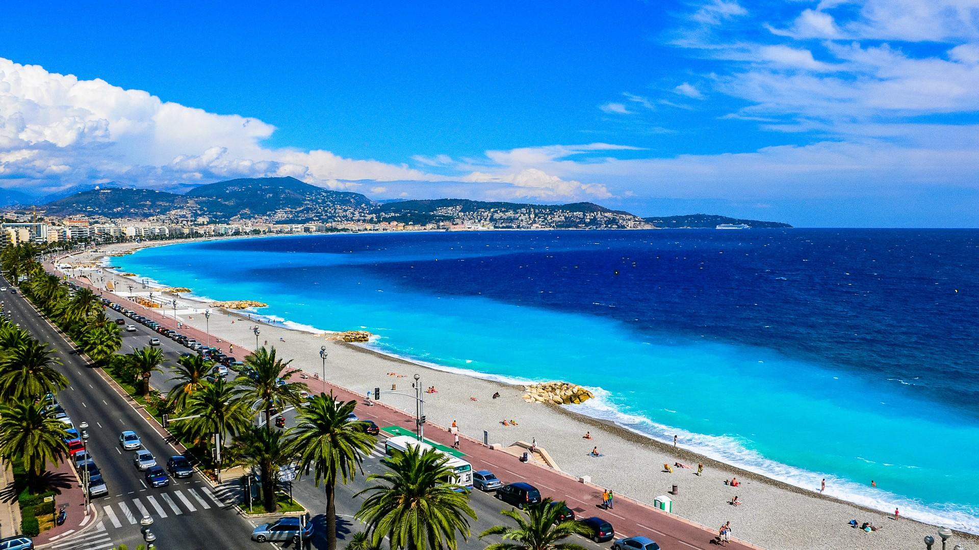 Beach with turquise water in Nice on a sunny day with some clouds