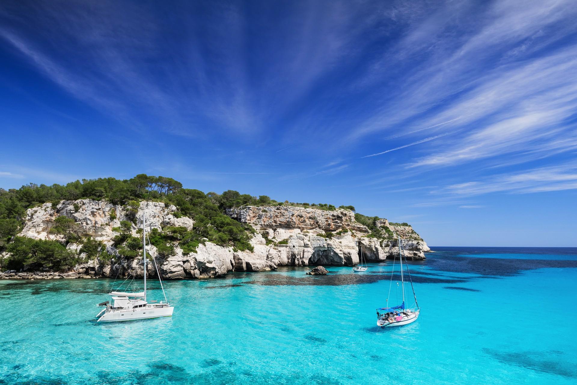 Beach with turquise water in Menorca on a sunny day with some clouds