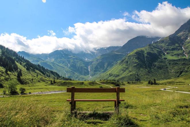 View of a bench, beautiful green mountains and hiking trails, Nassfeld
