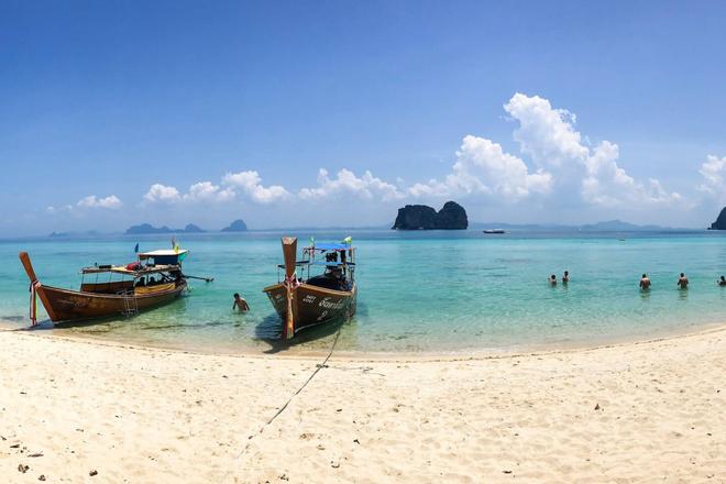 Boats, sea and white sandy beach in Ko Lanta