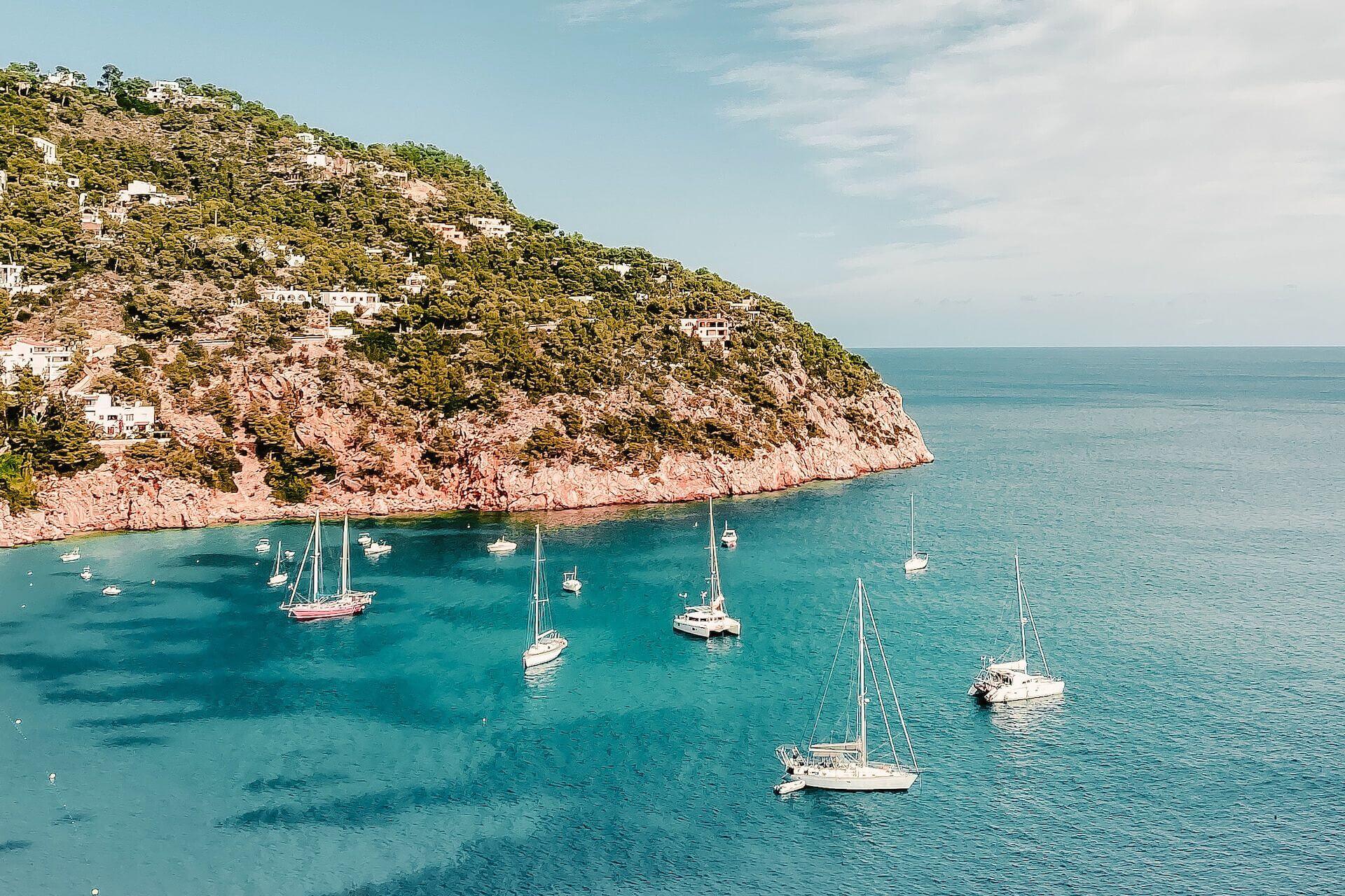 View of boats and yachts at sea and a part of the island of Ibiza
