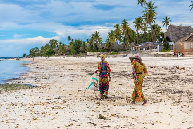 Zanzibar: women in traditional dress on the beach.