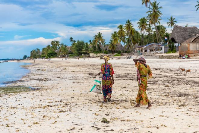 Zanzibar: women in traditional dress on the beach.