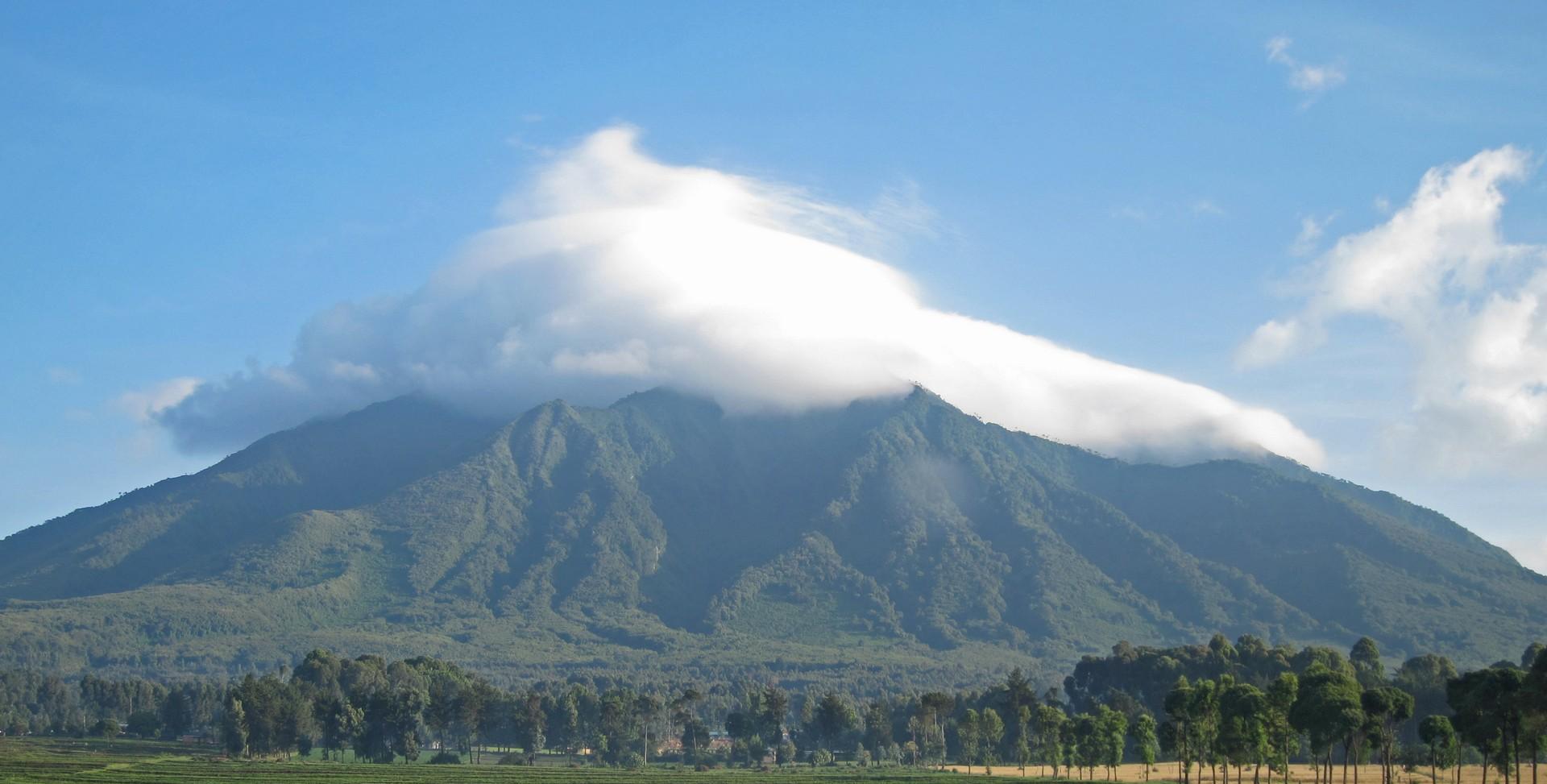 Mountain range in Parc National des Volcans on a sunny day with some clouds