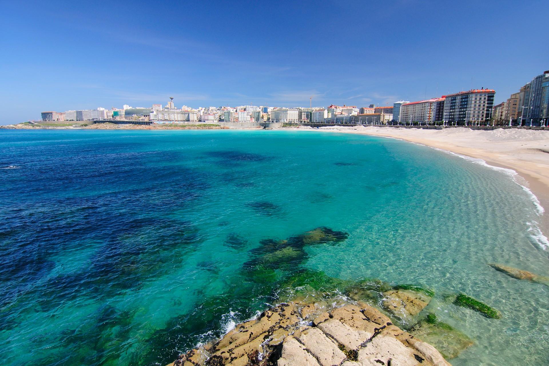 Beach with turquise water in La Coruna in sunny weather with few clouds