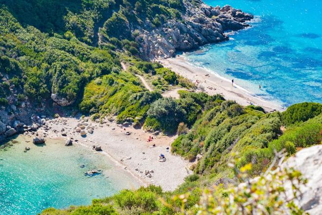 View of 2 beaches divided by greenery and a mountain in Corfu