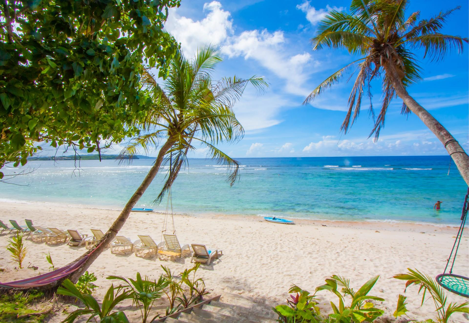 Nice beach by the sea in Saipan in sunny weather with few clouds