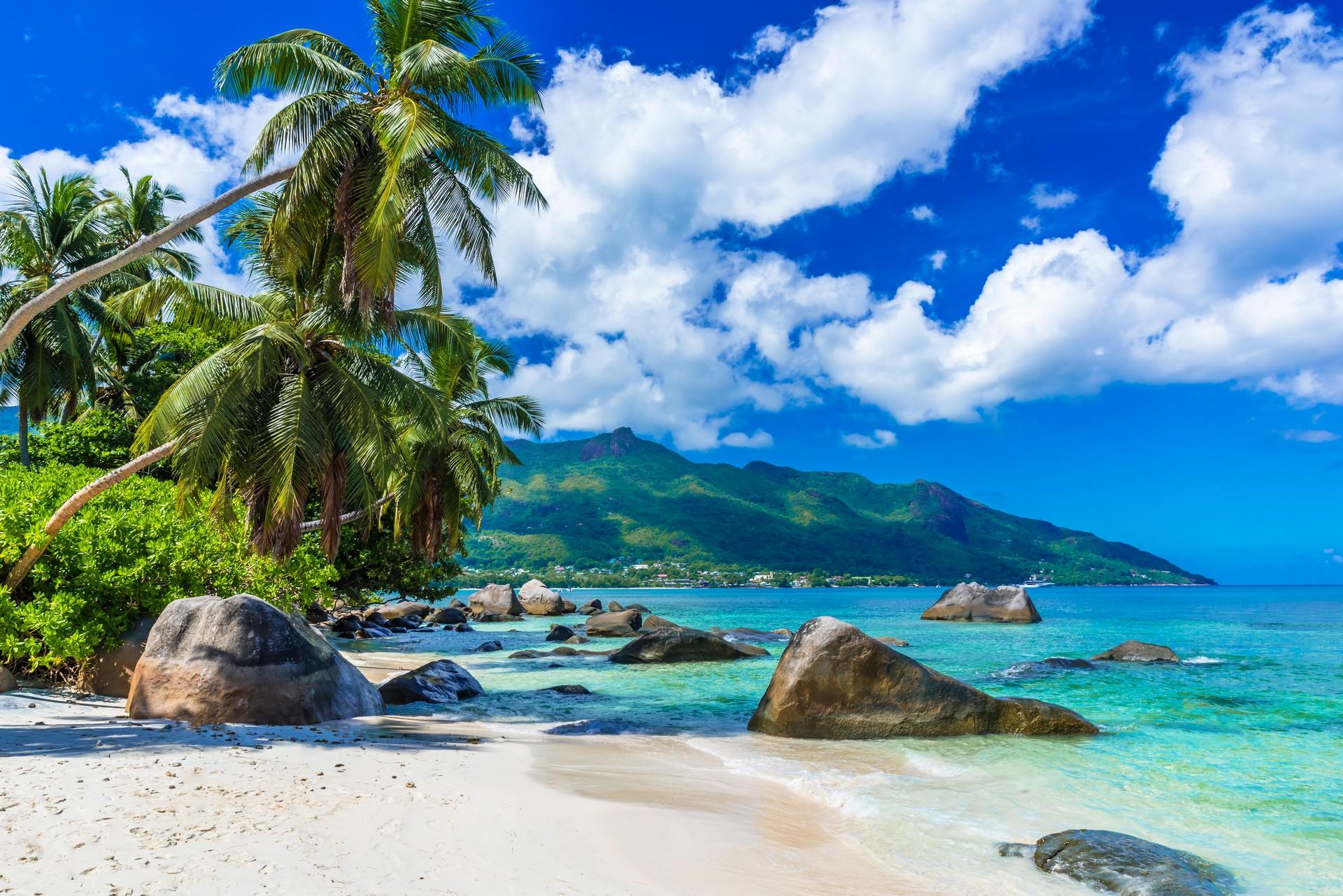 Beach with turquise water in Mahé in partly cloudy weather