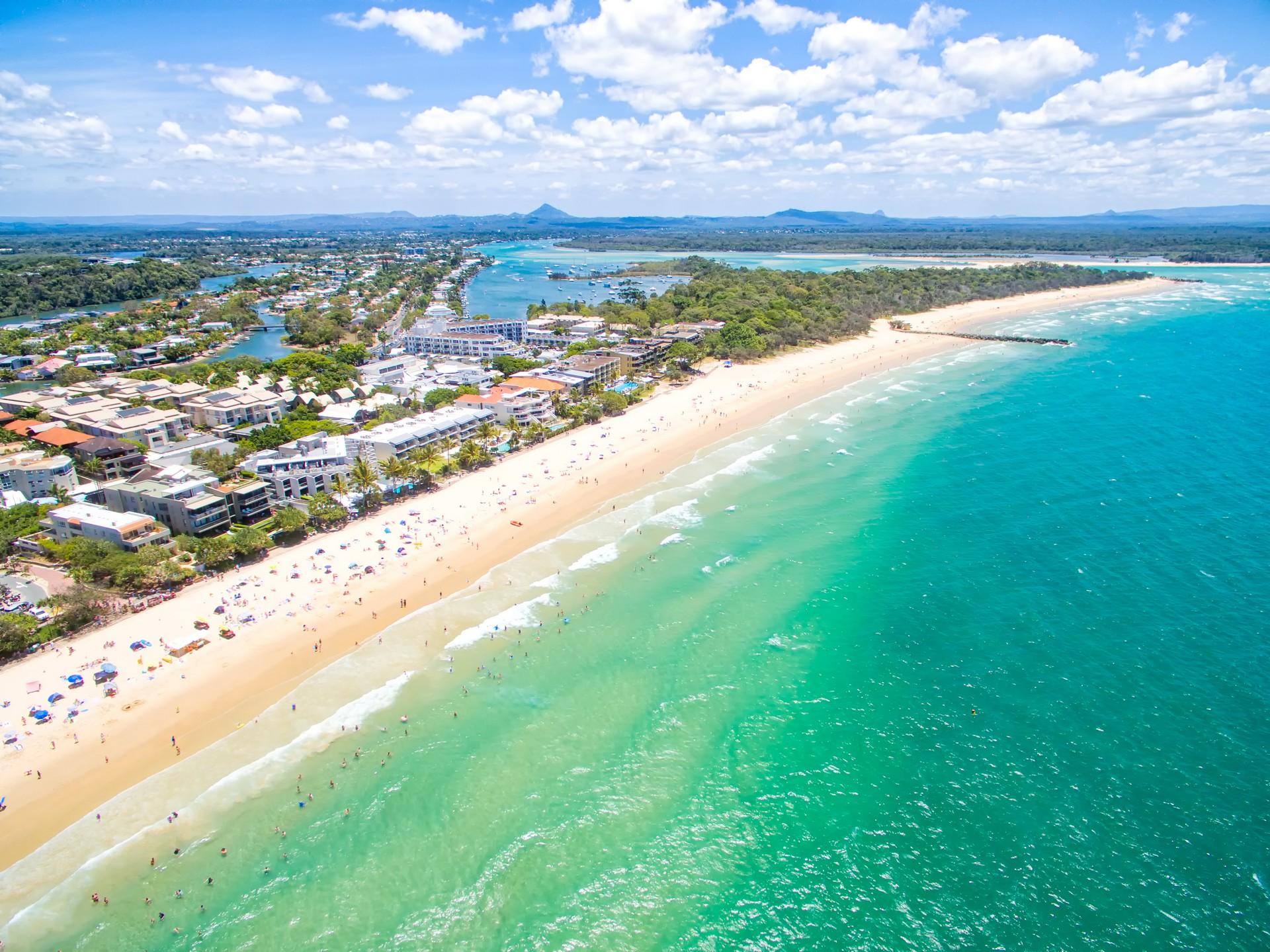 Aerial view of beach with a lot of people in Noosa Heads in sunny weather with few clouds