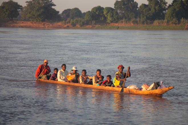 Wooden boat with local people on the Tsiribihina River in Madagascar.