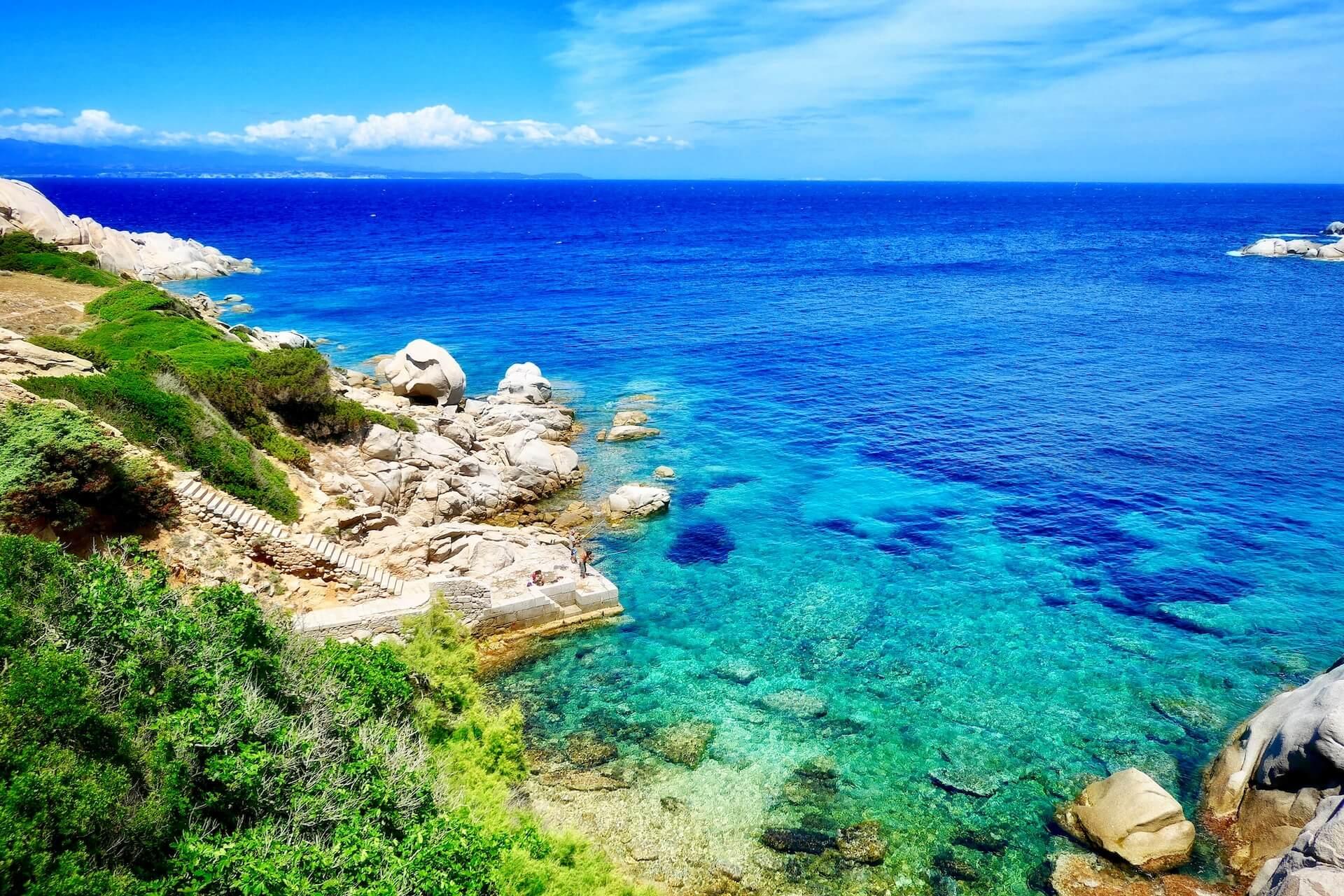 View of the azure sea with rocky steps in Sardinia