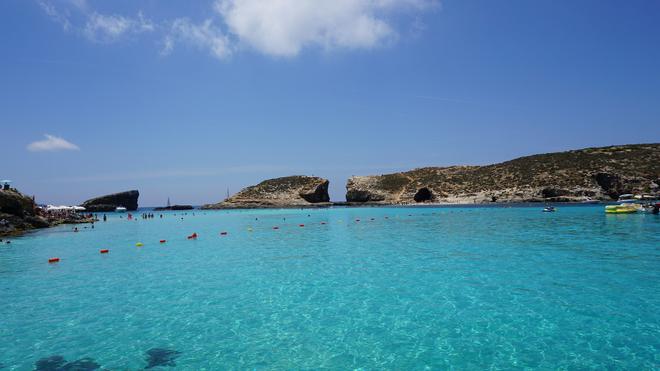 Malta, Blue Lagoon: people swimming in azure blue water.