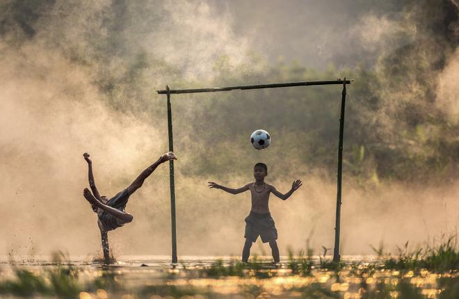Children playing football outside.