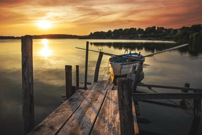 Premantura, Croatia: boat at the wooden pier at sunset.