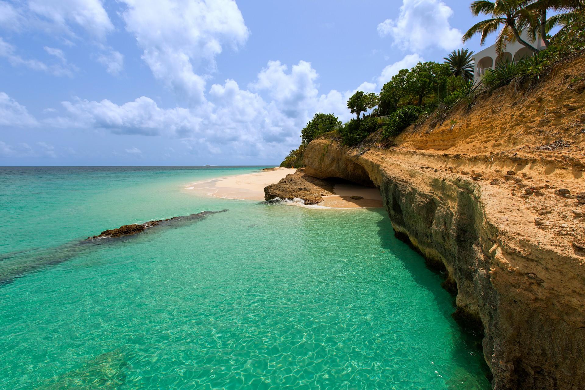 Beach with turquise water in Anguilla on a day with cloudy weather