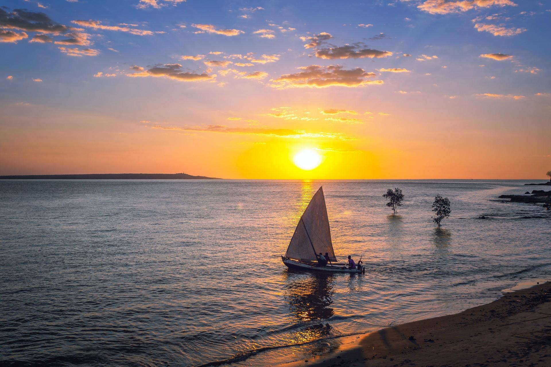 Madagascar: beach with sailing boat at sunset.