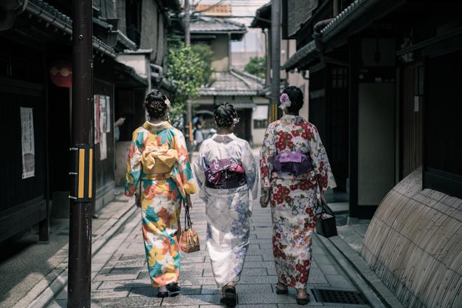 Japanese women in traditional dress walking down the street.