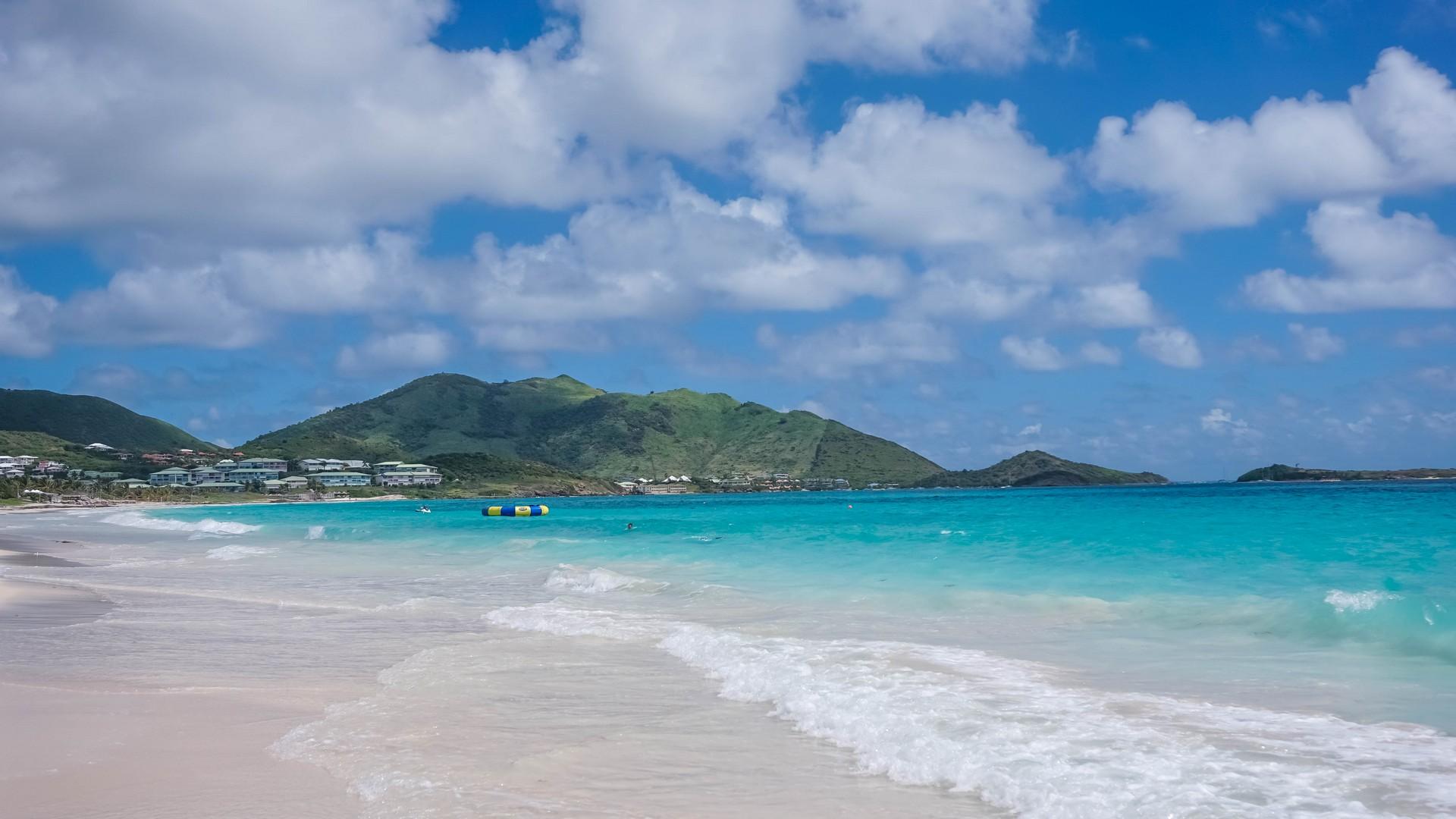 Beach with turquise water in Orient Bay in sunny weather with few clouds