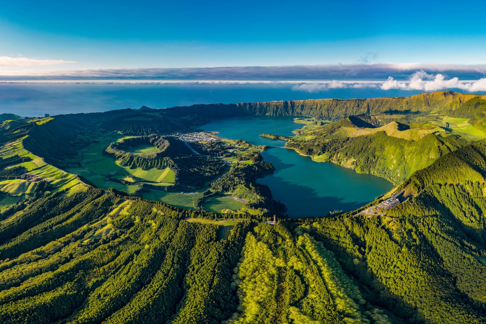 Aerial view of mountain range in Azores in sunny weather with few clouds