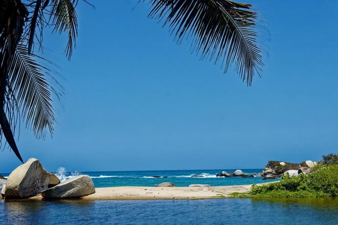 View of sea, beach, rocks and a palm in Tayrona NP, Colombia