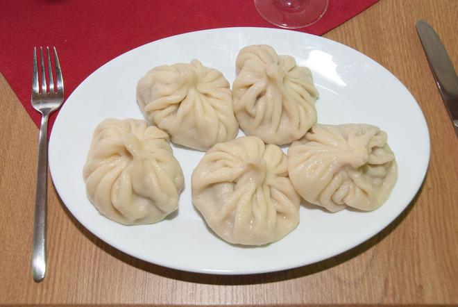 Georgian chinkali on a plate: boiled pouches filled with spiced minced meat.