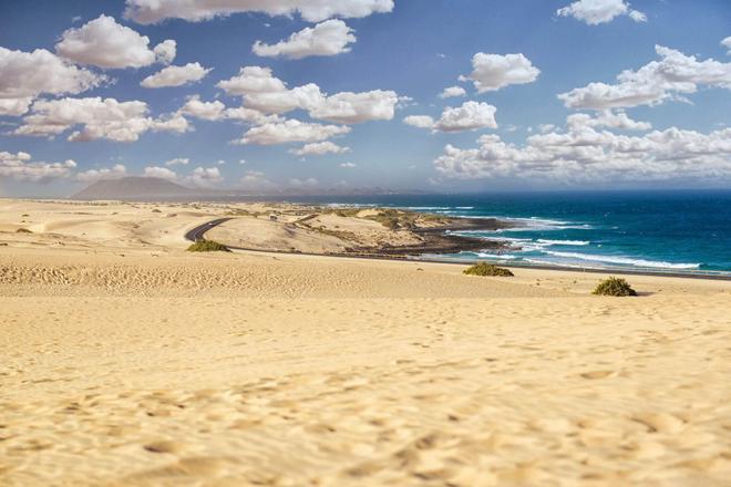 View of sand dunes, a highway and sea in Fuerventura, Canary Islands