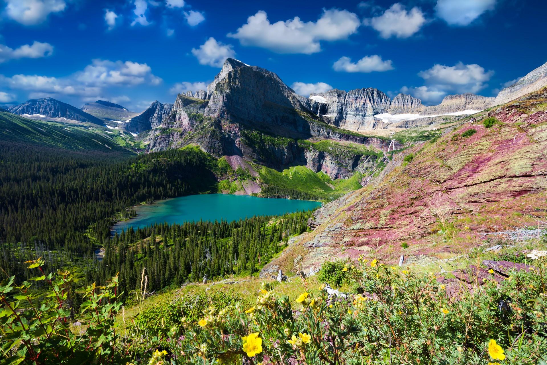 Mountain range in Glacier National Park in sunny weather with few clouds