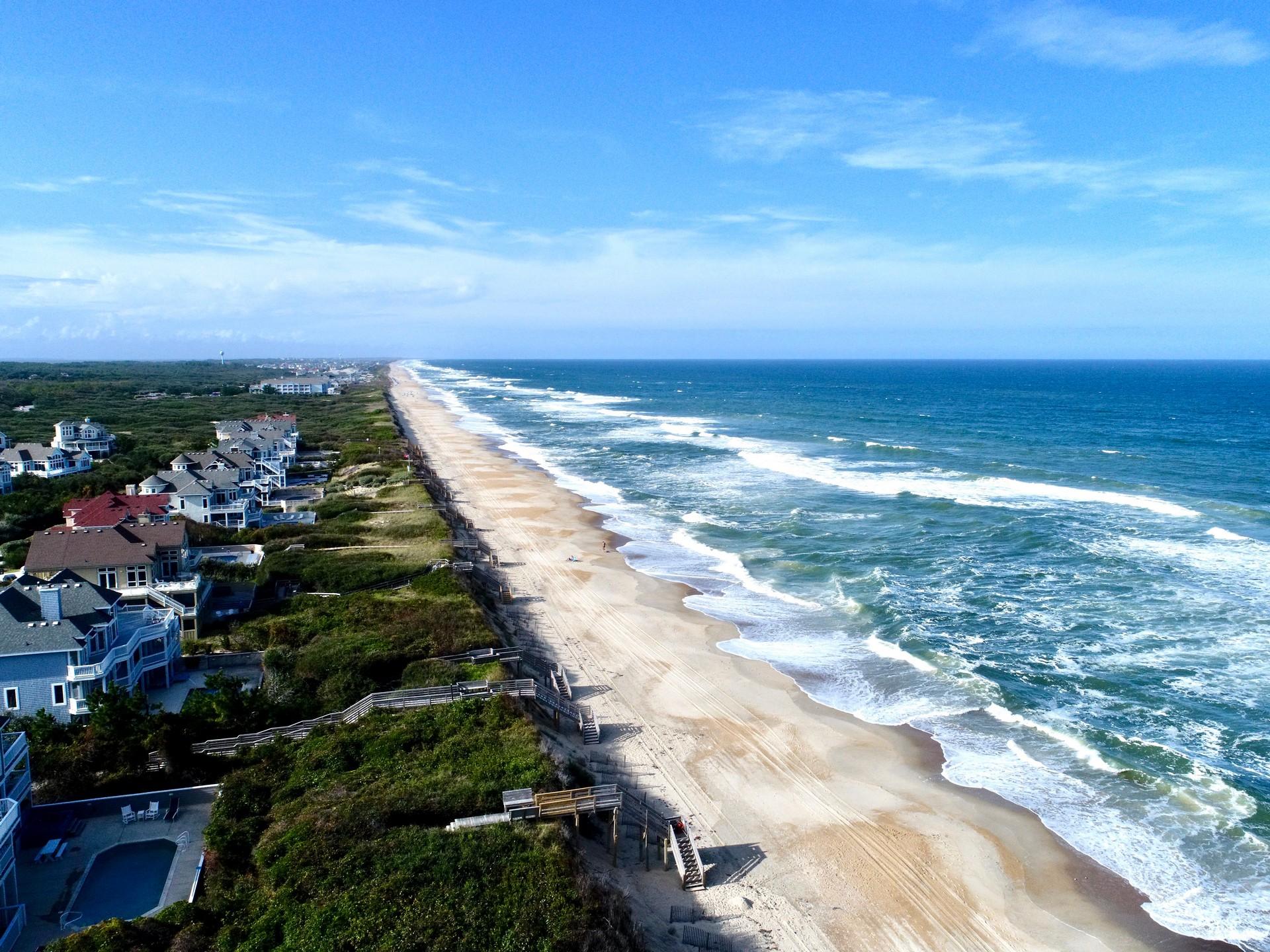 Aerial view of beach in Corolla on a sunny day with some clouds
