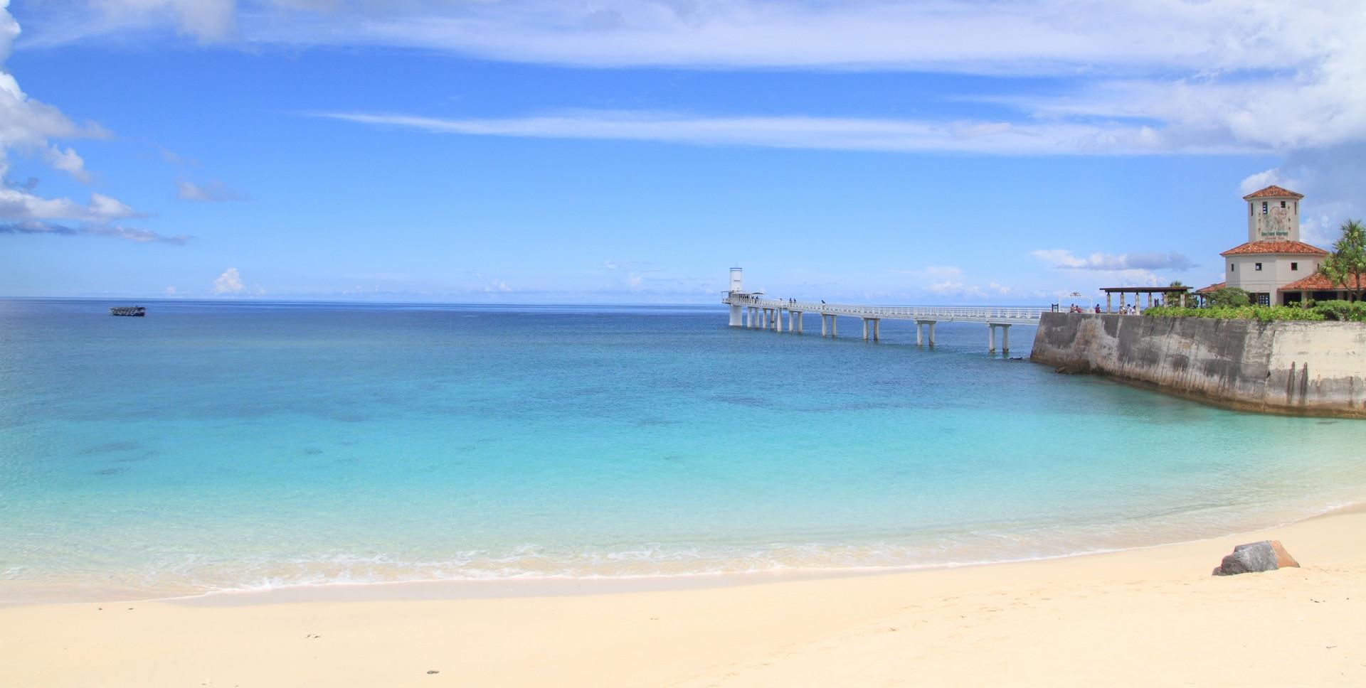 Nice beach by the sea and port near Nago in sunny weather with few clouds