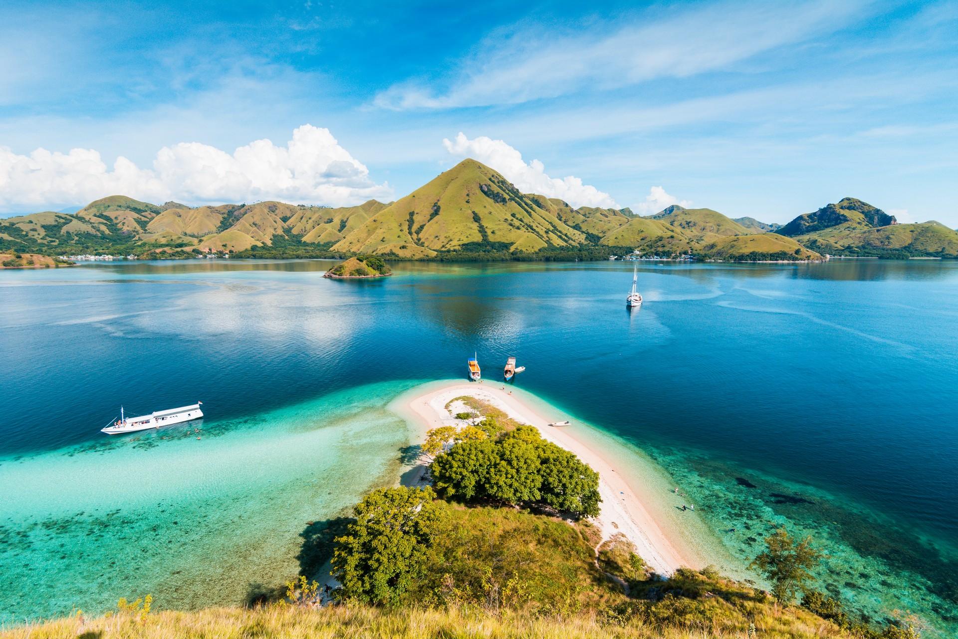 Beach with turquise water in Komodo on a sunny day with some clouds