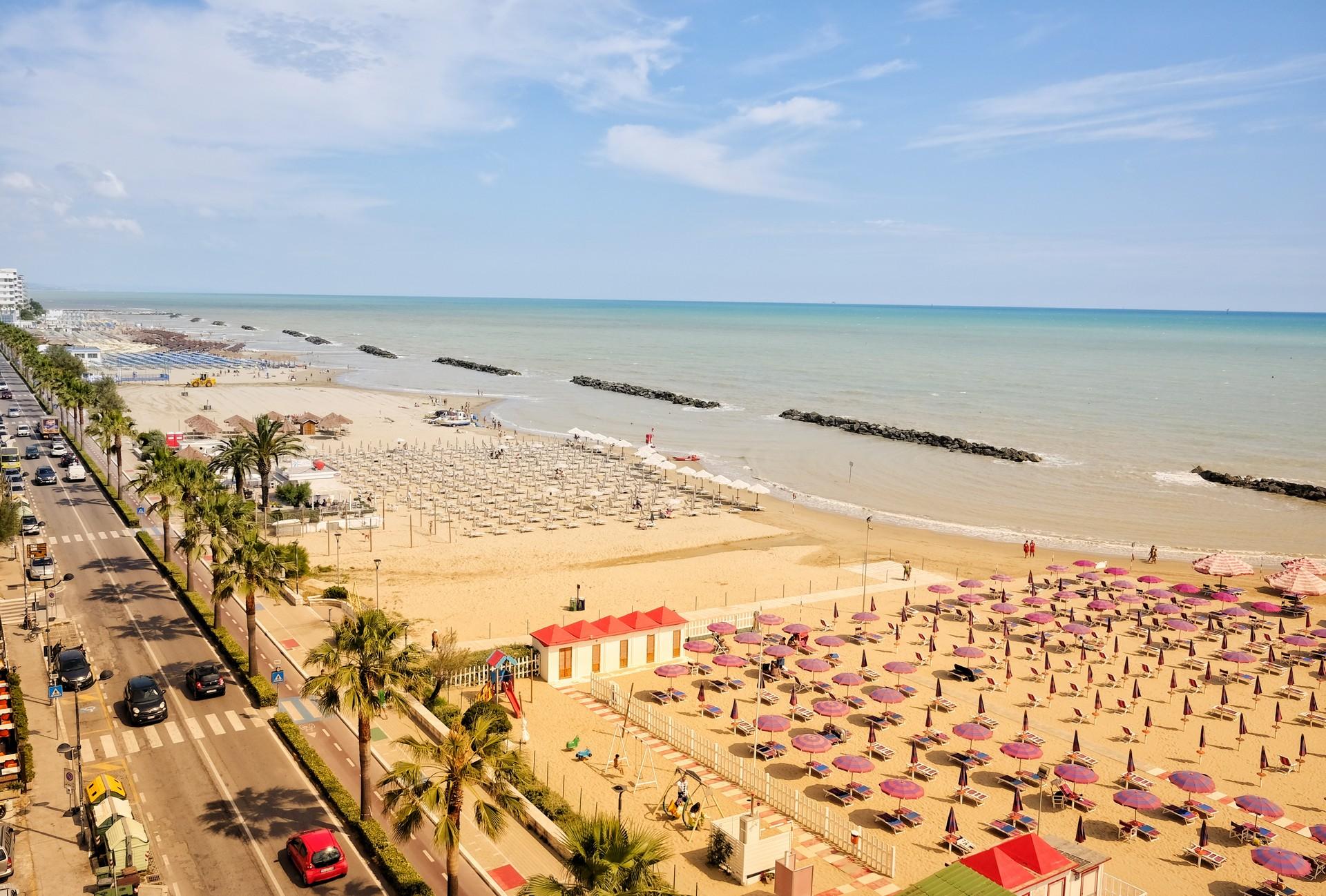 Beach with a lot of people and architecture in Montesilvano in partly cloudy weather