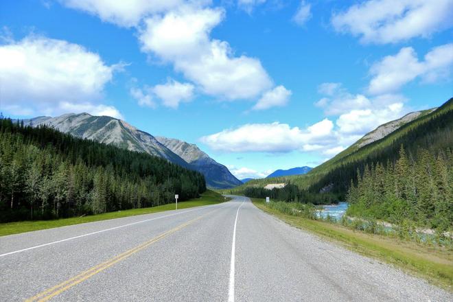 Alaska Highway in the middle of a forest and mountains