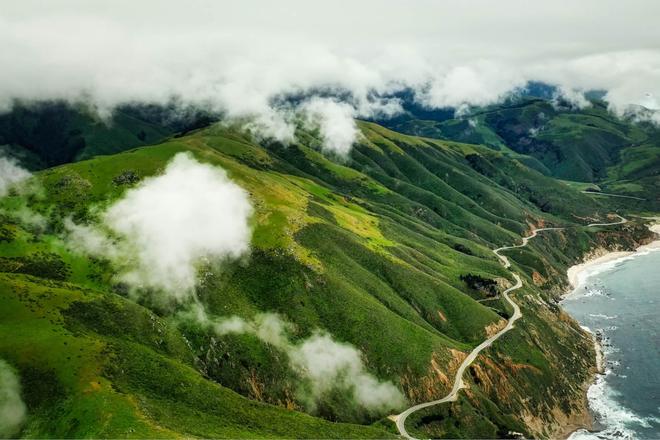 Green hills covered in clouds and surrounded by the sea