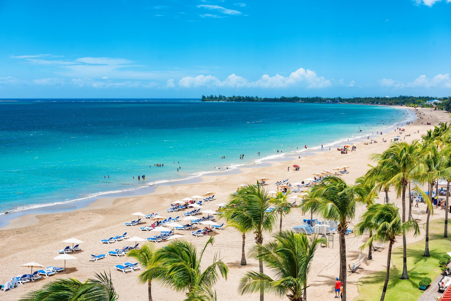 People on the beach in San Juan on a sunny day with some clouds