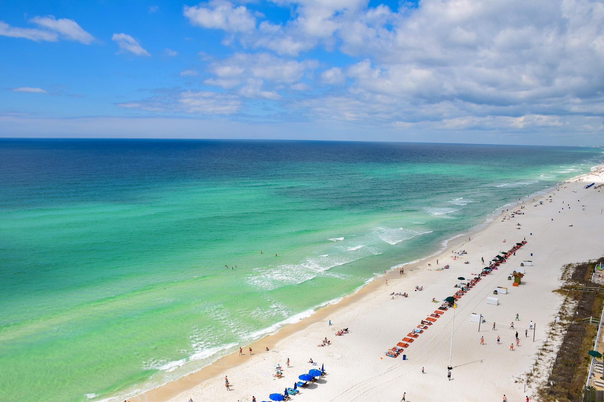 Beach with a lot of people with turquise water in Destin on a day with cloudy weather