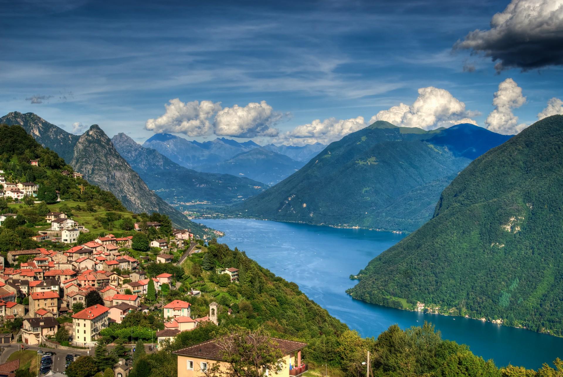 Aerial view of mountain range near Lugano in sunny weather with few clouds