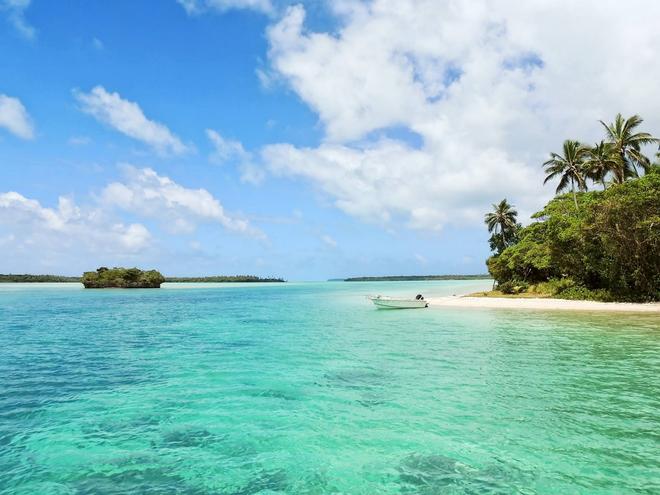 Caribbean beach in Jamaica with white sand, azure sea and boat.