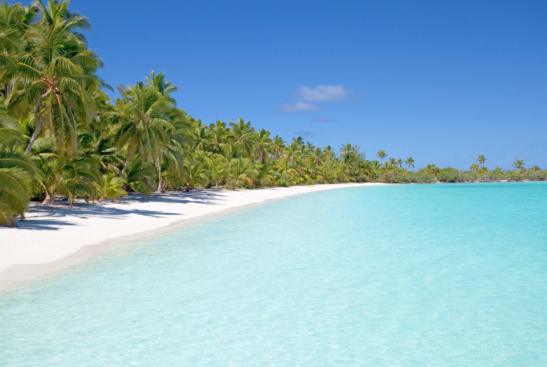 Nice beach by the sea with turquise water in Aitutaki on a clear sky day