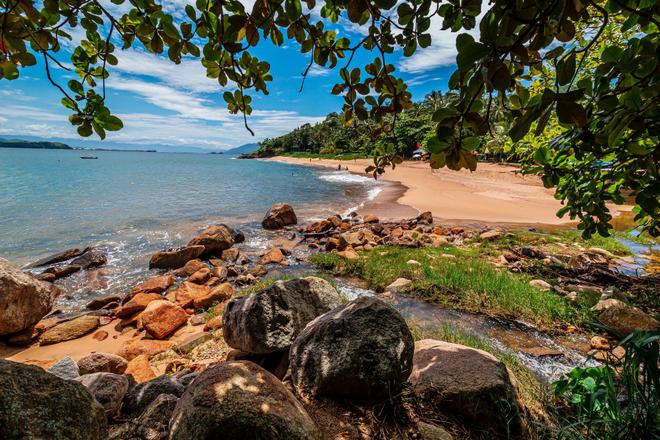 Brazil - Southeast coast sunny beach with trees and rocks .