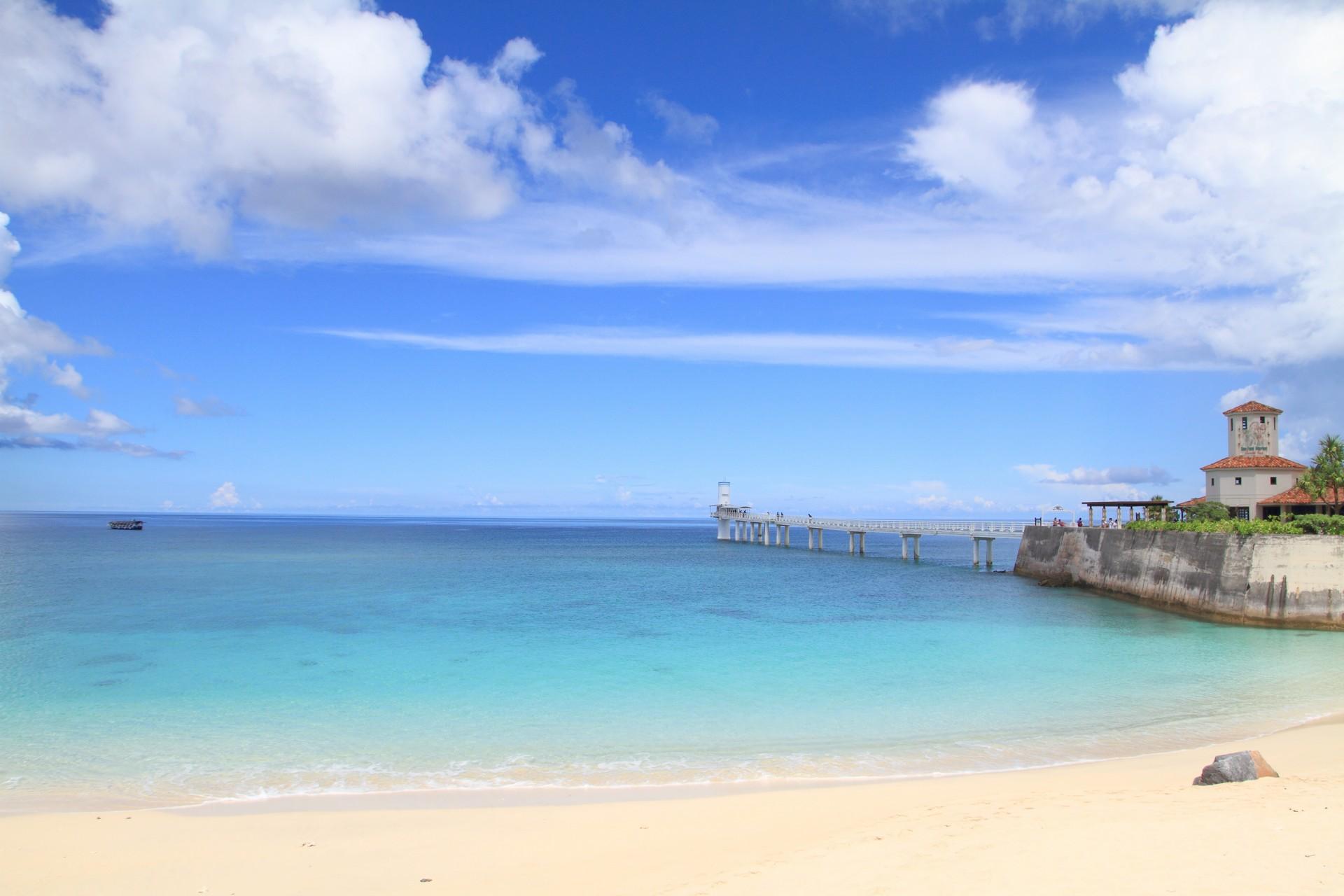 Nice beach by the sea and port near Nago in sunny weather with few clouds